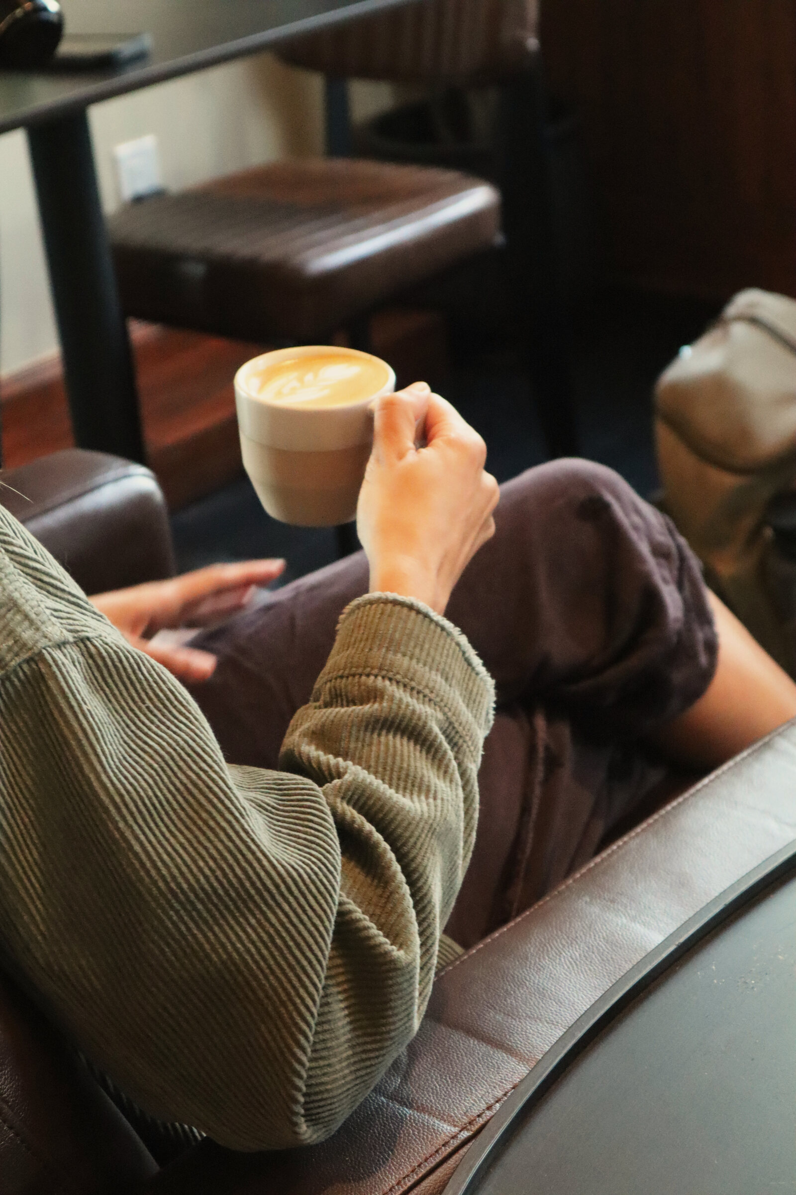 A hand holding a cup of coffee