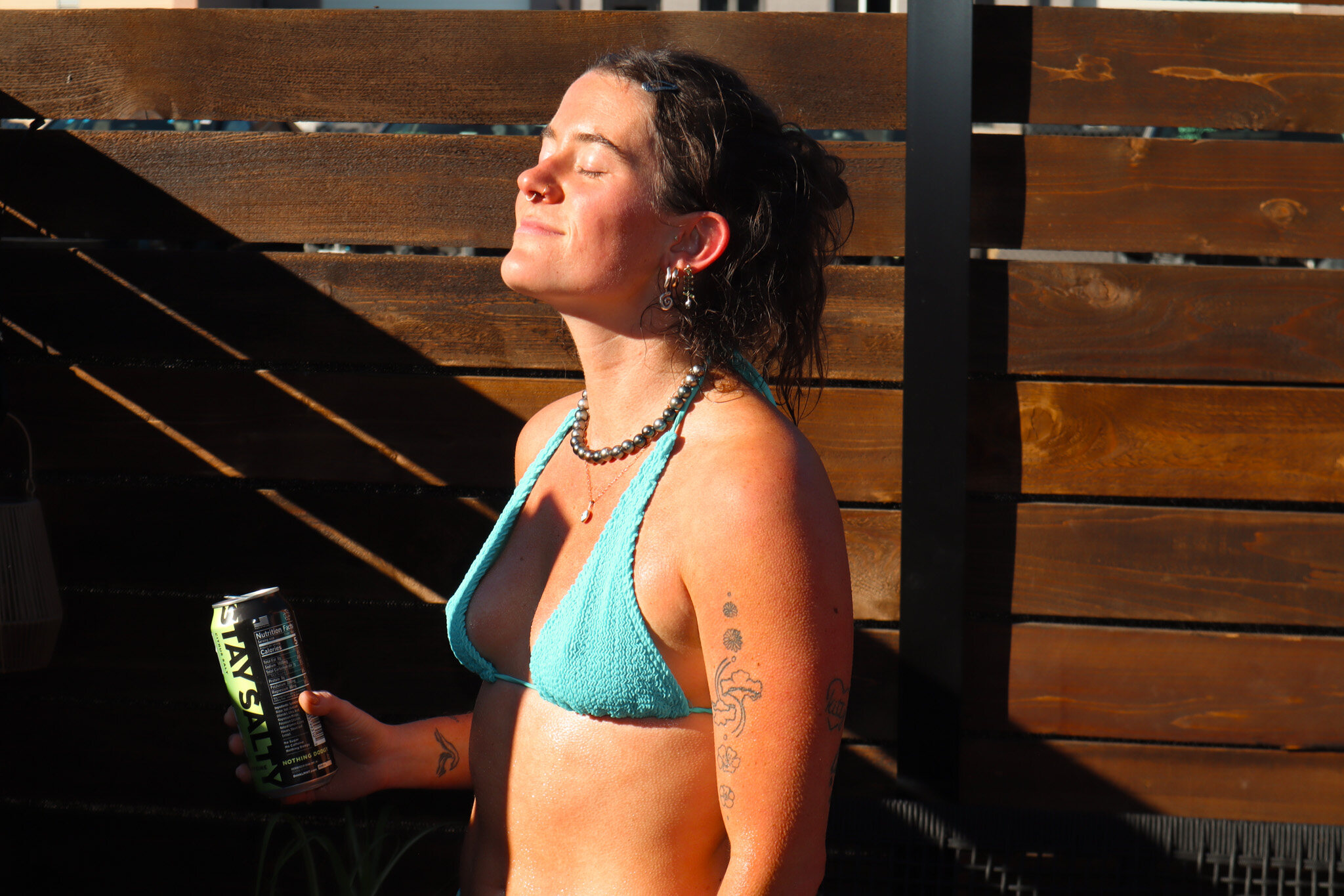 A woman with eyes closed in the late afternoon sun