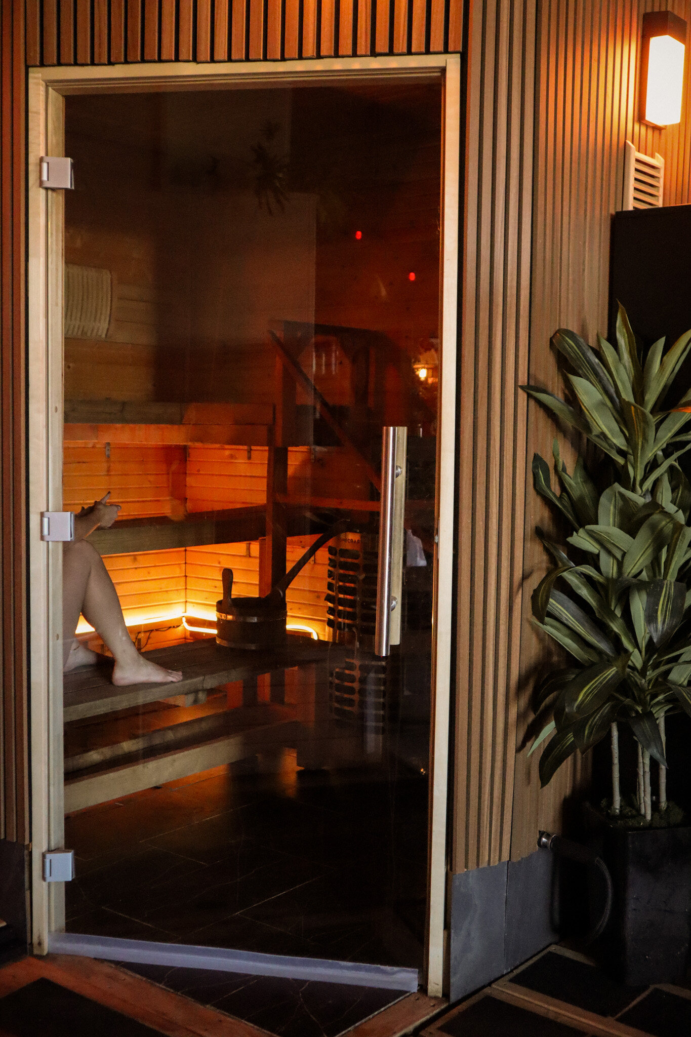 A cedar sauna door glowing from inside